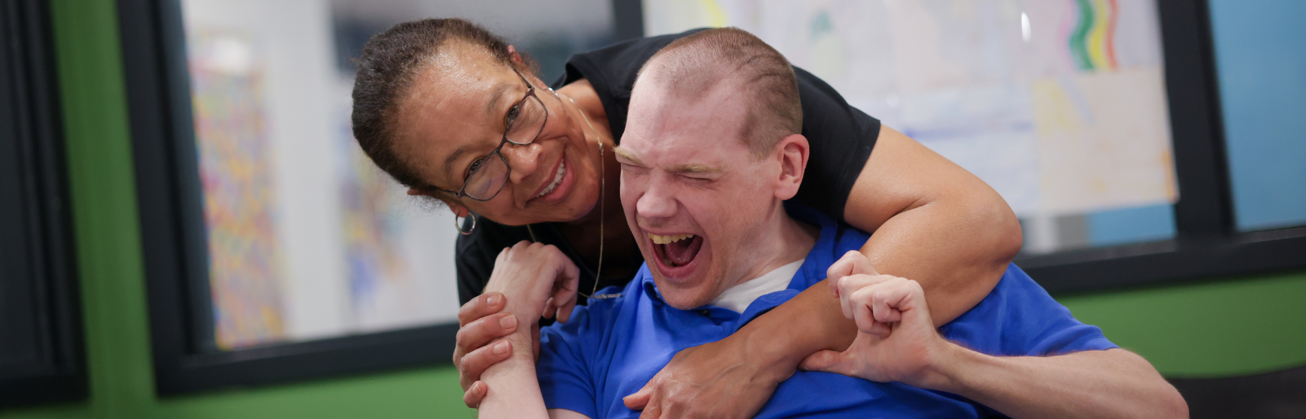 A Direct Support Professional hugging a man we support.