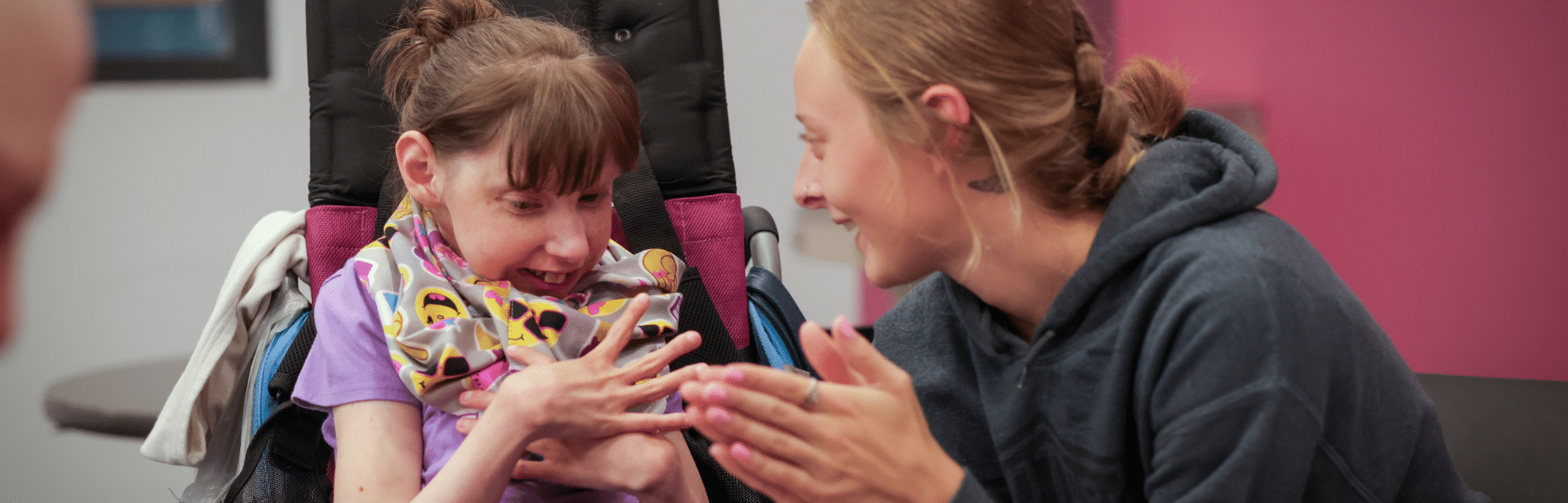 A woman in a wheelchair smiling at her DSP.